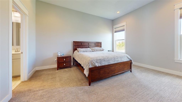 carpeted bedroom featuring sink and ensuite bathroom