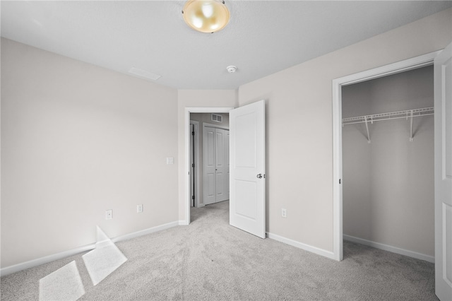 unfurnished bedroom featuring light carpet and a closet