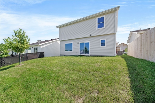 back of property featuring a lawn and central air condition unit