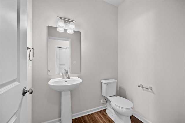 bathroom featuring wood-type flooring, toilet, and sink