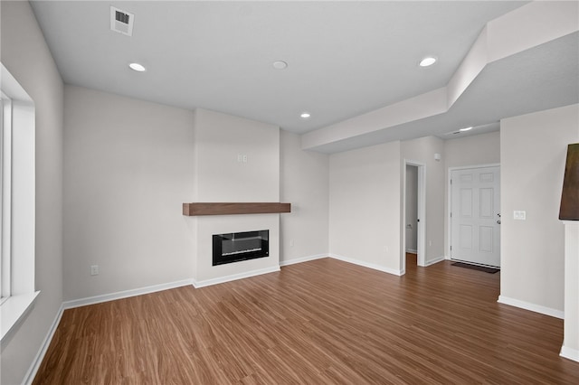 unfurnished living room with dark hardwood / wood-style flooring