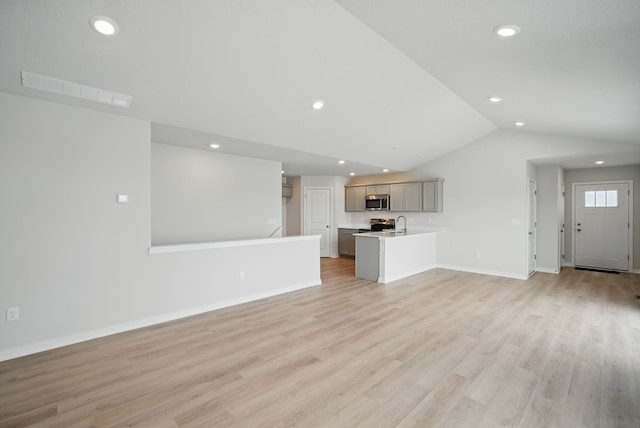 unfurnished living room with recessed lighting, visible vents, vaulted ceiling, and baseboards