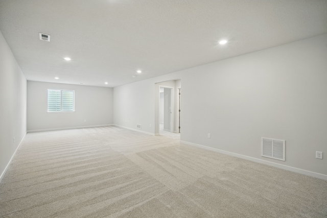 empty room with visible vents, light carpet, and recessed lighting