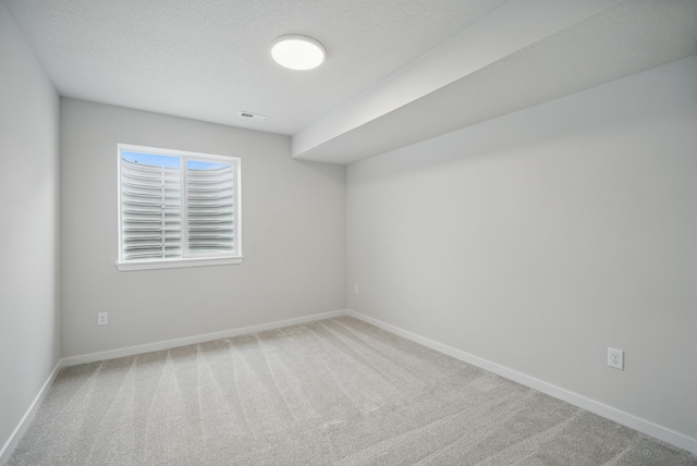carpeted empty room with visible vents and baseboards
