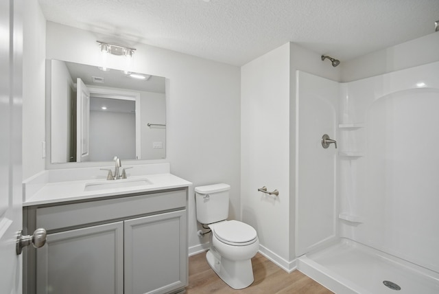 full bath featuring walk in shower, wood finished floors, toilet, and vanity