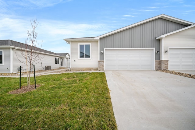 view of front of property with a garage, cooling unit, and a front yard