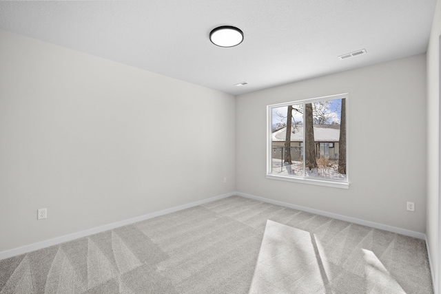 spare room with light carpet, baseboards, and visible vents