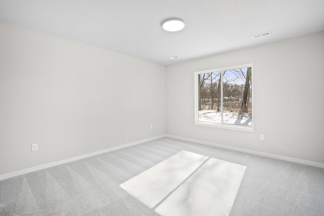 empty room featuring light carpet, baseboards, and visible vents