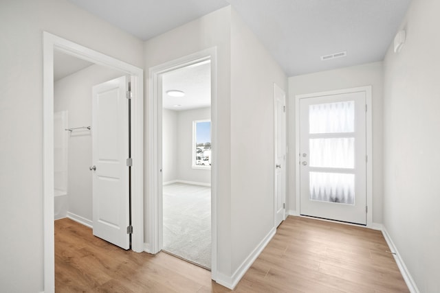 interior space featuring baseboards, visible vents, and light wood-style floors