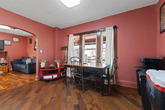 dining area featuring dark hardwood / wood-style floors and a textured ceiling