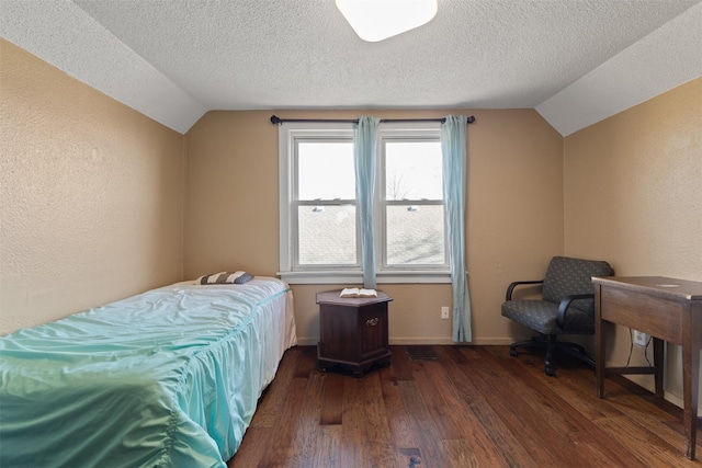 bedroom featuring dark hardwood / wood-style flooring, vaulted ceiling, and a textured ceiling