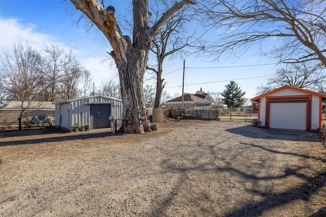 view of yard featuring a garage and an outbuilding