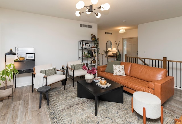 living room with an inviting chandelier and hardwood / wood-style flooring