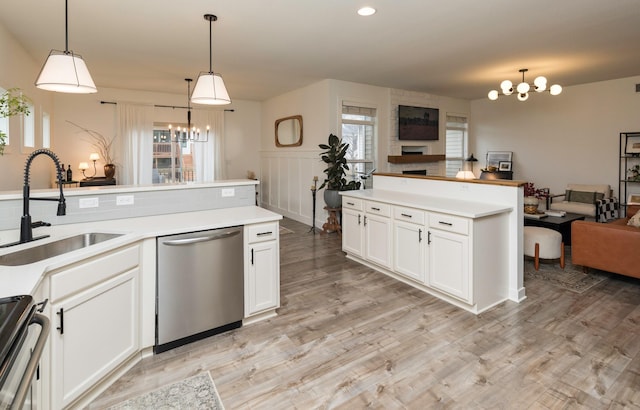 kitchen featuring pendant lighting, stainless steel appliances, sink, and an inviting chandelier