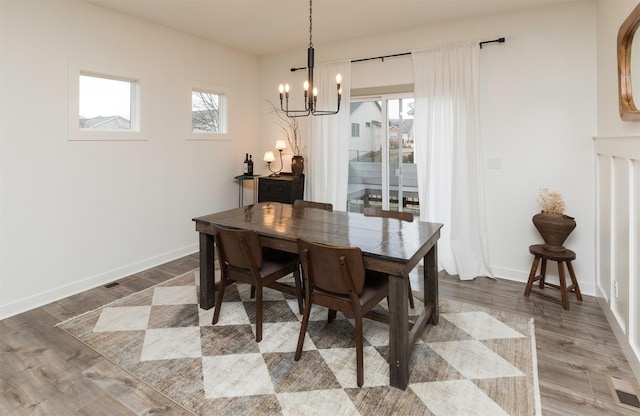 dining room with hardwood / wood-style floors and a chandelier