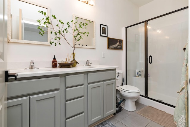 bathroom with vanity, tile patterned flooring, a shower with shower door, and toilet