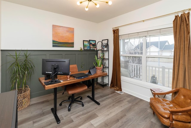 home office with hardwood / wood-style floors and a chandelier