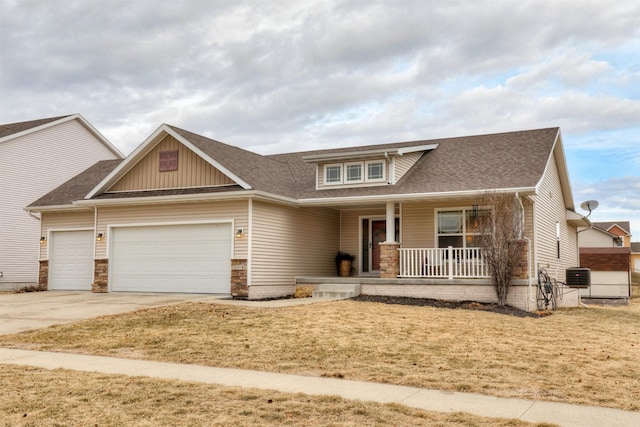 craftsman inspired home featuring a porch, a garage, a front yard, and central air condition unit