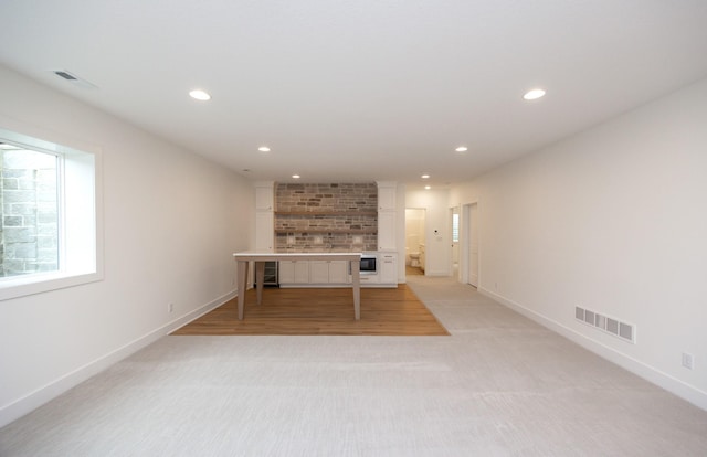 unfurnished living room featuring light carpet