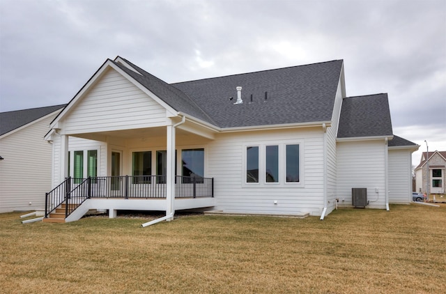 back of property with cooling unit and a yard