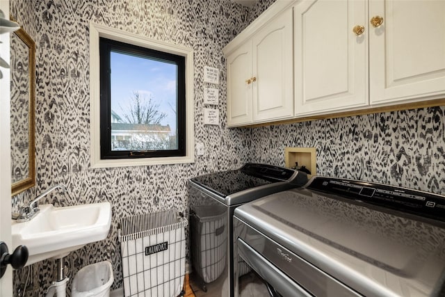 laundry room featuring cabinets, washer and clothes dryer, and sink