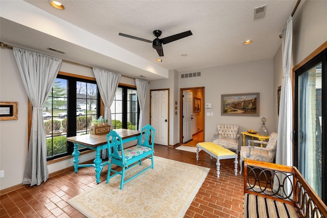 dining space featuring ceiling fan and a textured ceiling