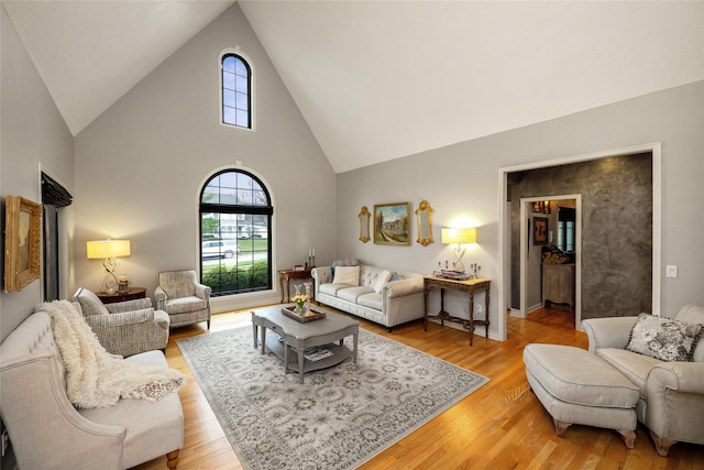 living room featuring high vaulted ceiling and light wood-type flooring