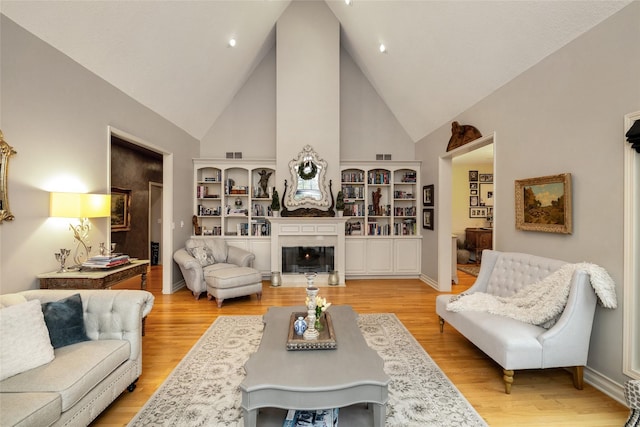 living room featuring high vaulted ceiling and light hardwood / wood-style floors