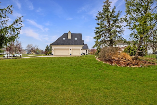 rear view of property featuring a yard and a garage