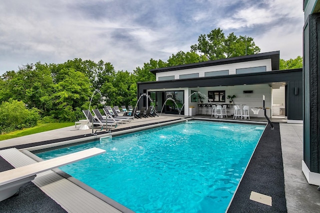 view of pool featuring a patio area and a diving board