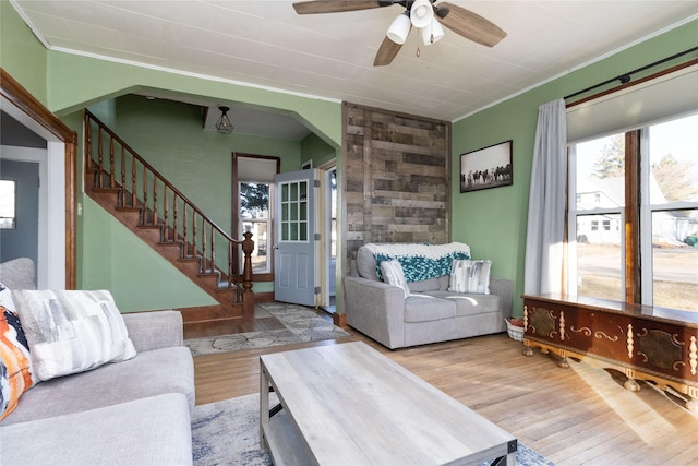 living room featuring crown molding, ceiling fan, and light hardwood / wood-style flooring