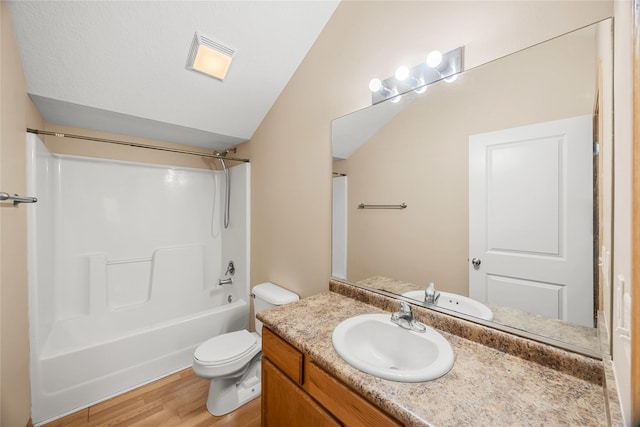 full bathroom with vaulted ceiling, hardwood / wood-style floors, bathtub / shower combination, vanity, and toilet