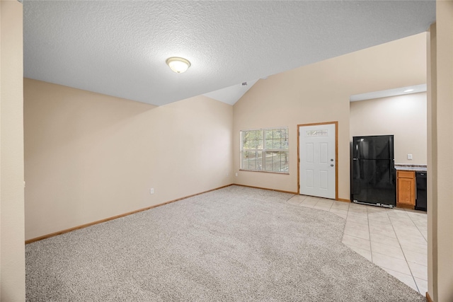 unfurnished living room with vaulted ceiling, a textured ceiling, and light tile patterned floors