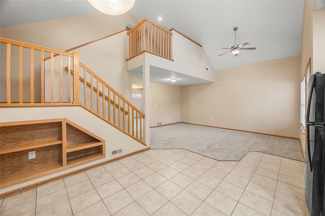 unfurnished living room with light carpet, high vaulted ceiling, and ceiling fan