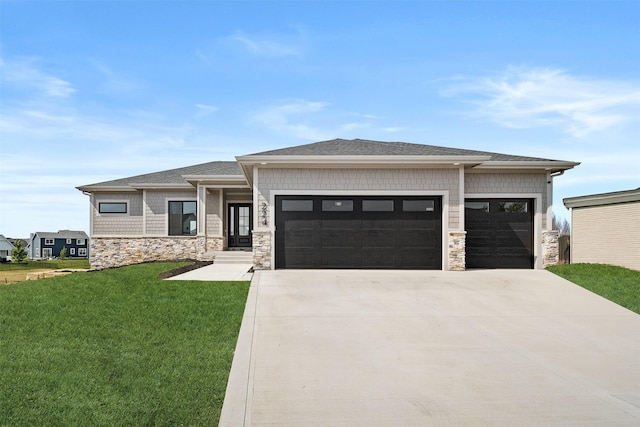 prairie-style home featuring a garage and a front lawn