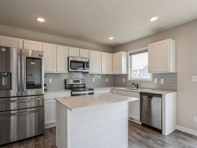 kitchen with white cabinetry, dark hardwood / wood-style floors, a center island, and appliances with stainless steel finishes