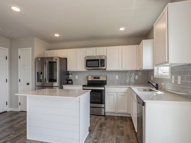 kitchen with sink, white cabinetry, dark hardwood / wood-style flooring, a kitchen island, and stainless steel appliances