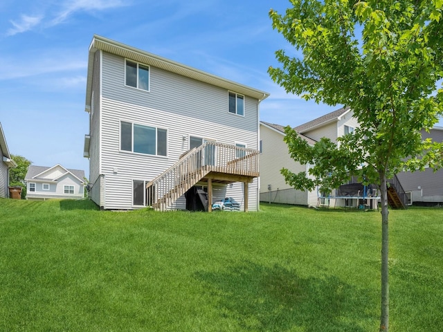 back of property with a wooden deck and a yard