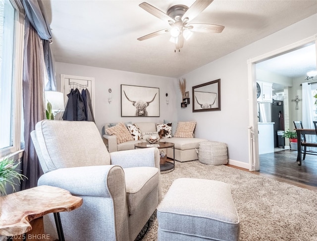 living room featuring hardwood / wood-style flooring, a wealth of natural light, and ceiling fan