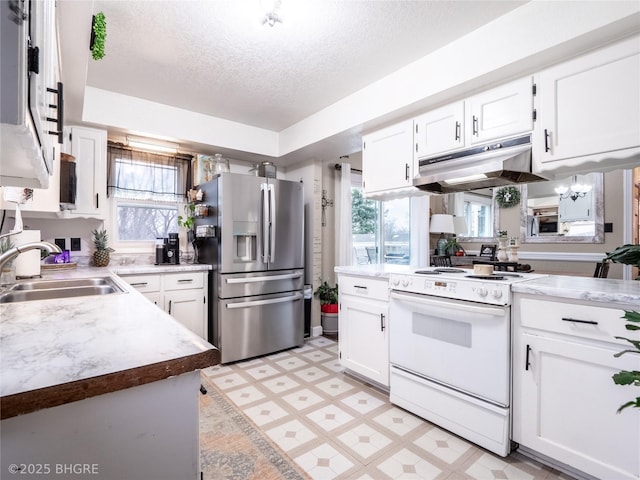 kitchen featuring electric stove, sink, white cabinetry, a textured ceiling, and stainless steel fridge with ice dispenser