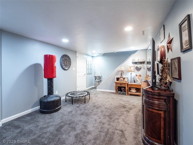 sitting room featuring carpet flooring and a textured ceiling