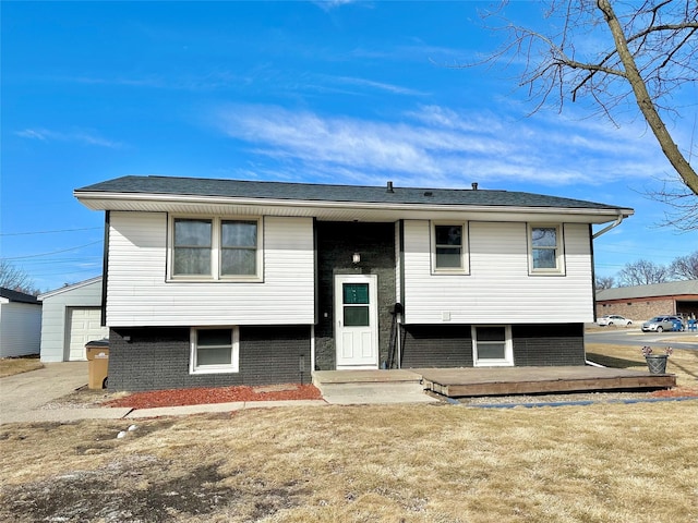 view of front of home featuring a front lawn, an outdoor structure, and brick siding