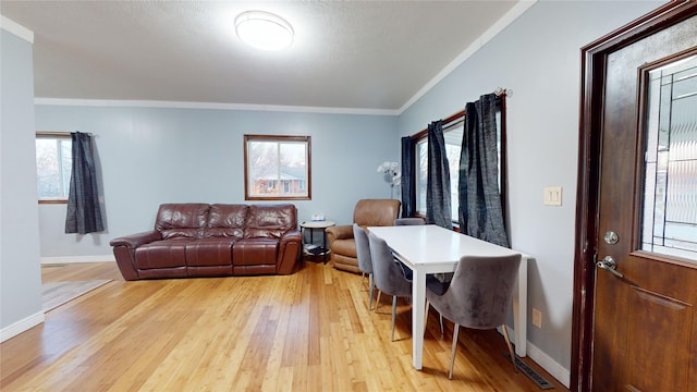 living room with ornamental molding, light hardwood / wood-style floors, and a textured ceiling