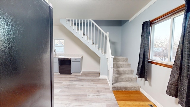 staircase with sink and hardwood / wood-style floors