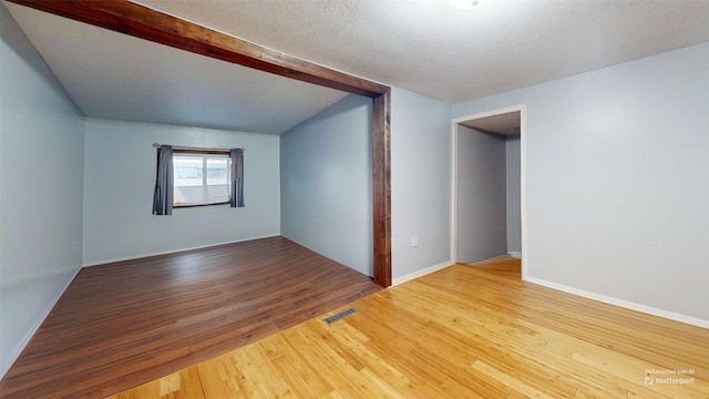 unfurnished room with wood-type flooring and a textured ceiling