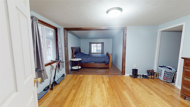 bedroom with a textured ceiling and light hardwood / wood-style floors