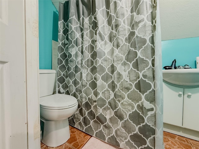 bathroom featuring toilet and curtained shower