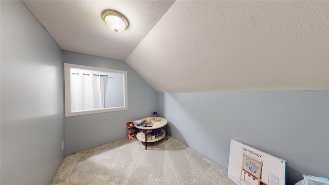 carpeted bedroom featuring lofted ceiling and a textured ceiling