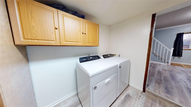 washroom with cabinets, ornamental molding, washer and dryer, and light wood-type flooring