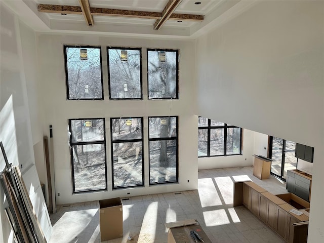 living room with beam ceiling, coffered ceiling, and a towering ceiling